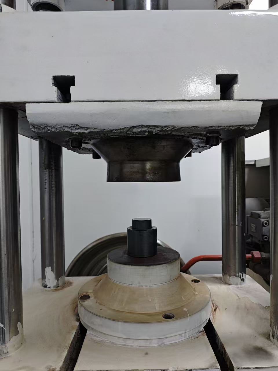 Laboratory press with a cylindrical sample positioned between its plates